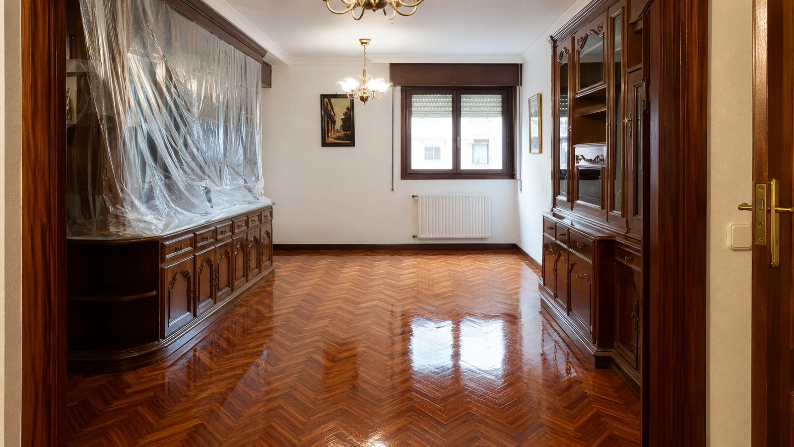 Salón con suelo de parquet en espiga recién barnizado y acabado brillante