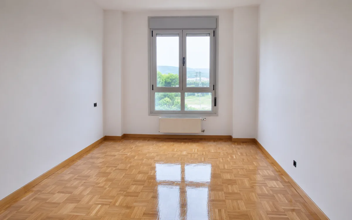 Habitación luminosa con parquet recién barnizado y acabado brillante